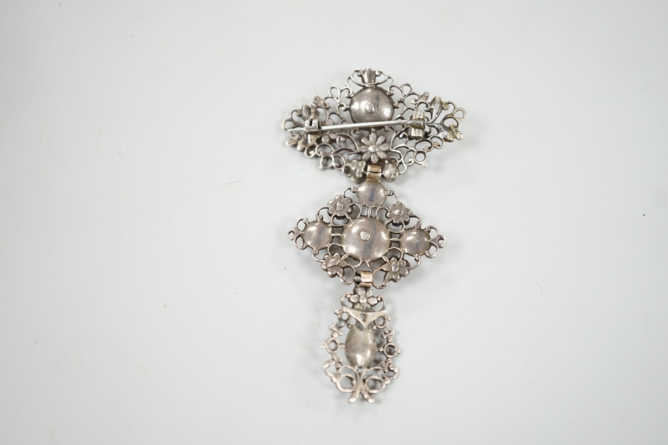 A continental antique pierced white and yellow metal, diamond set three tier drop brooch, 70mm, gross weight 13.2 grams.